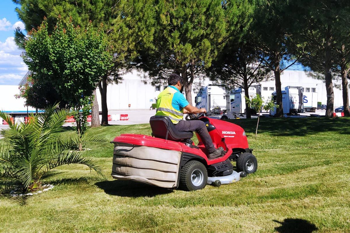 trattore rasa erba su prato area industriale