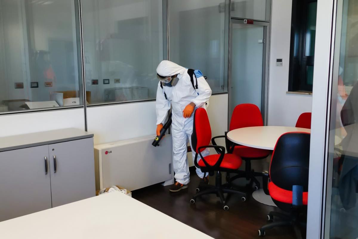 operatore che sanifica l'interno di un ufficio aziendale
